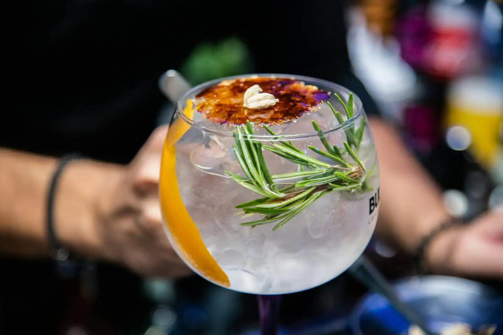 Cocktail sans alcool dans un verre à pied avec tonic pamplemousse rose et brin de romarin