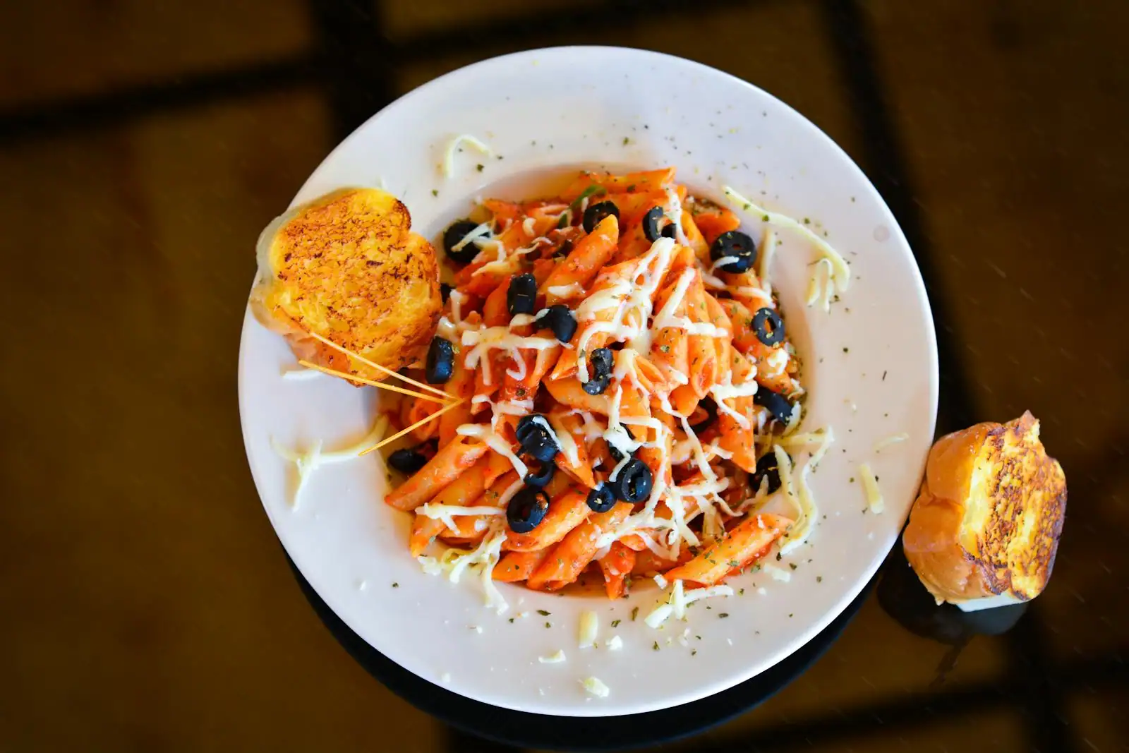 Plat simple de pâtes à l'ail et à l'huile d'olive dressé dans une assiette blanche, plan de travail clair