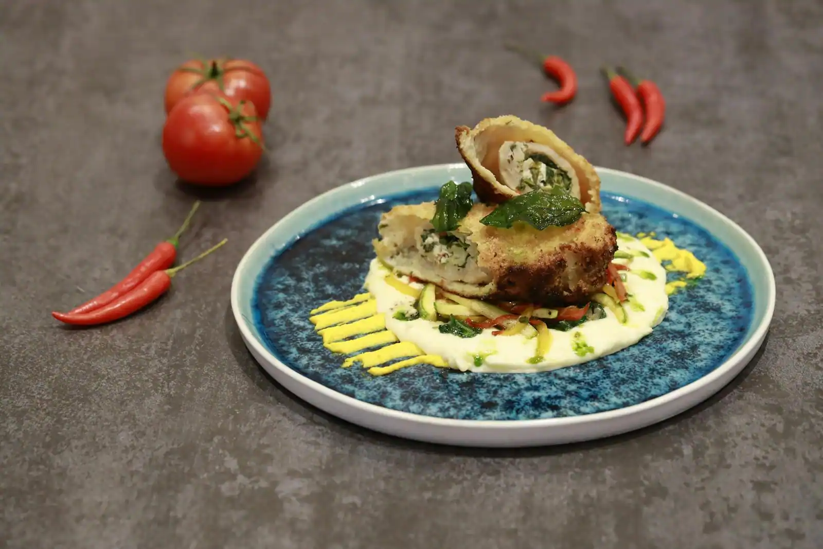 Plat principal coloré et soigné servi dans une assiette en céramique avec garniture fraîche