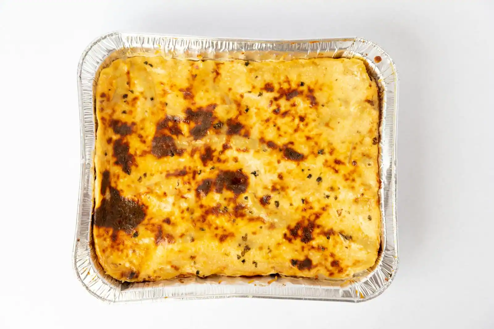 Lasagne végétarienne aux courgettes et ricotta sortie du four, dorée, dans un plat en céramique