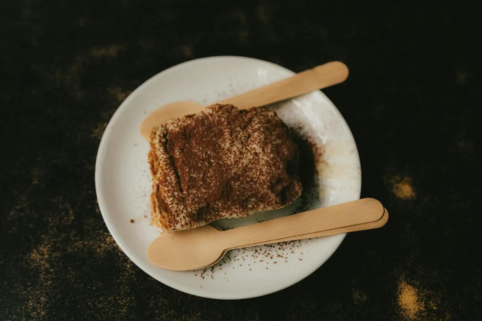Tiramisu speculoos servi en portions individuelles, couches visibles de crème mascarpone et de speculoos, poudre brune saupoudrée juste avant service