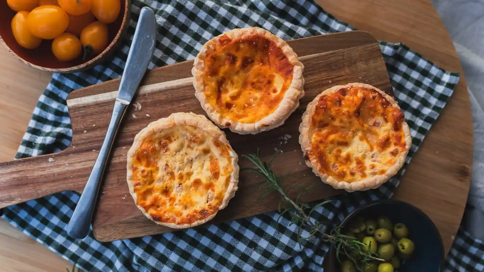 Quiche végétarienne aux poireaux et chèvre coupée en parts sur planche en bois clair