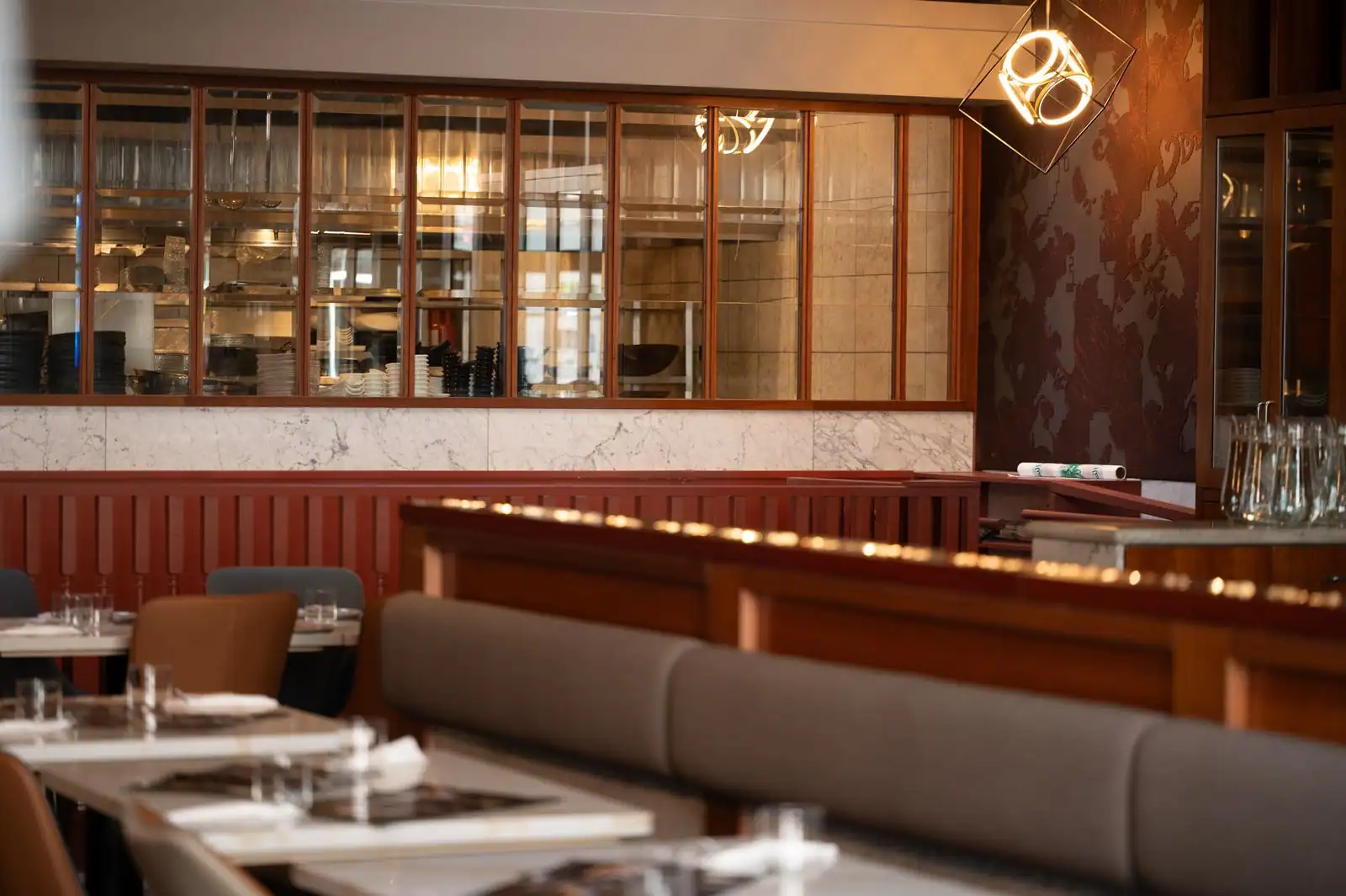 Salle de restaurant tendance toulousaine avec cuisine ouverte et lumière chaude de soirée