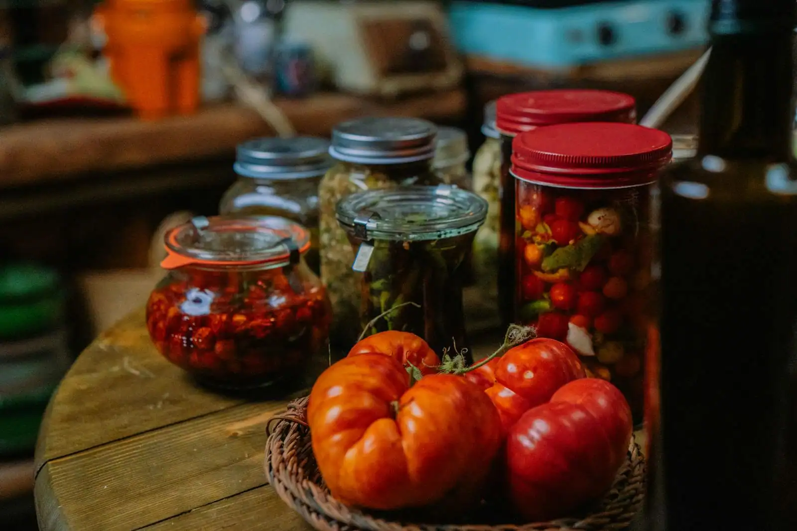 Bocaux de légumes fermentés et herbes fraîches sur un plan de travail en bois clair