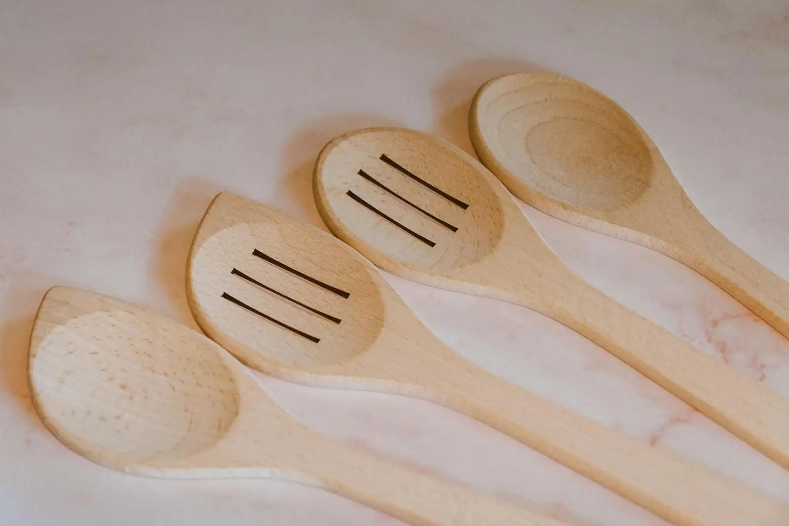 Cuillères et spatules en bois alignées sur un plan de travail clair