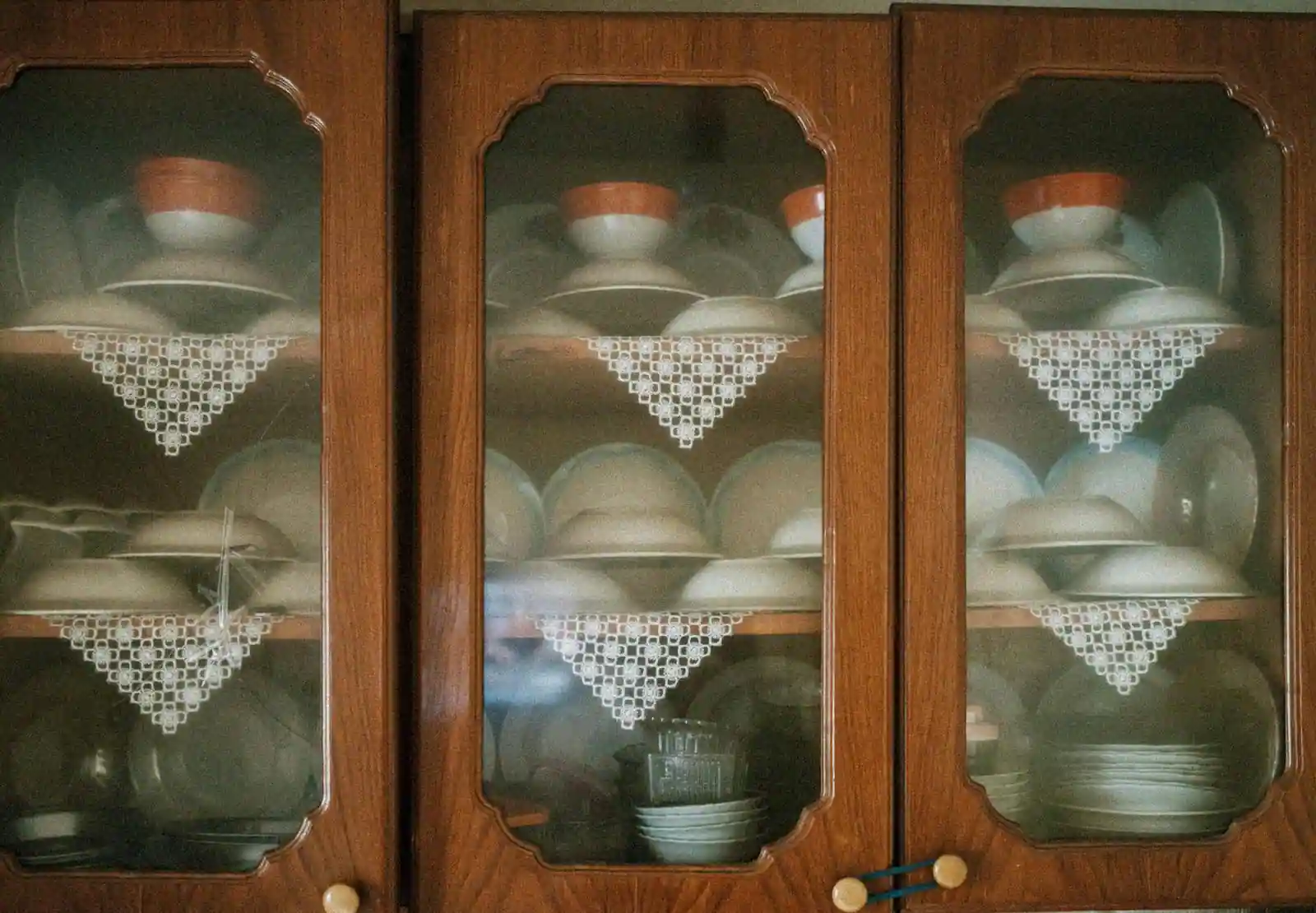 Vaisselle ancienne, ramequins en grès et plats à four en verre disposés sur une table en bois, lumière naturelle d'atelier