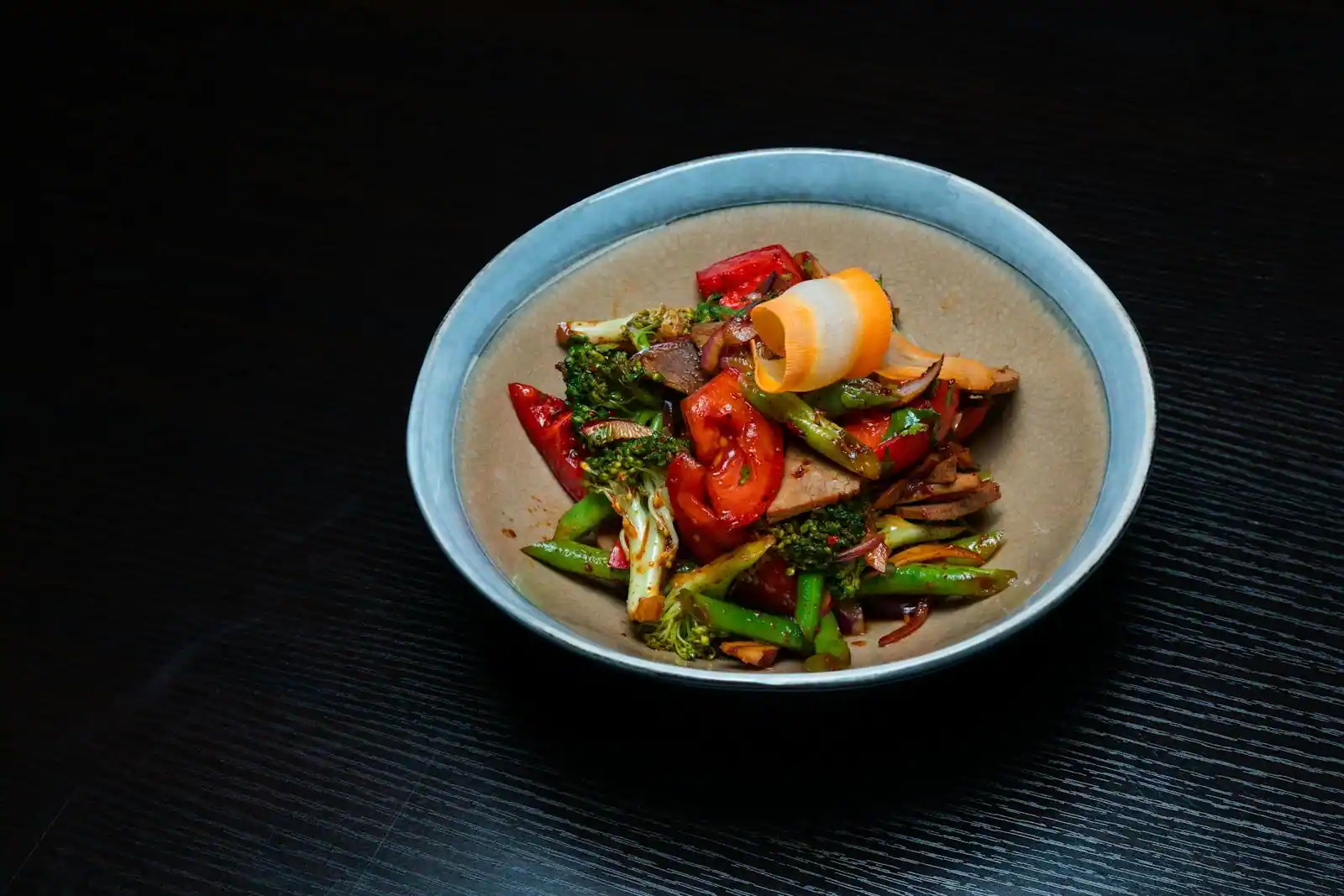 Wok de légumes colorés sautés (brocoli, carottes, poivrons) avec graines de sésame sur le dessus