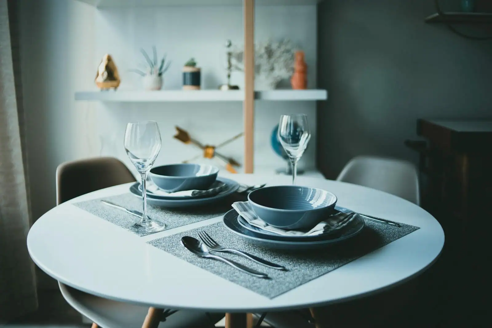 Table dressée avec soin : assiettes, couverts alignés, verres et serviette en lin