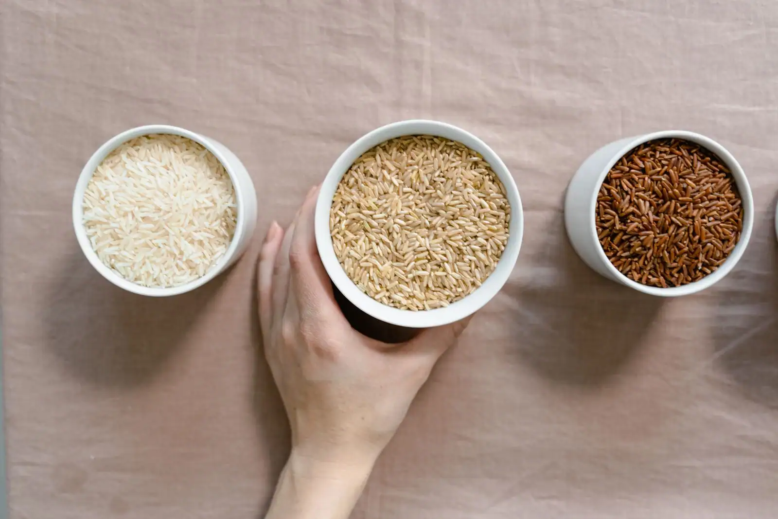 Trois bols de riz — blanc, complet et rouge —, une céréale naturellement sans gluten.