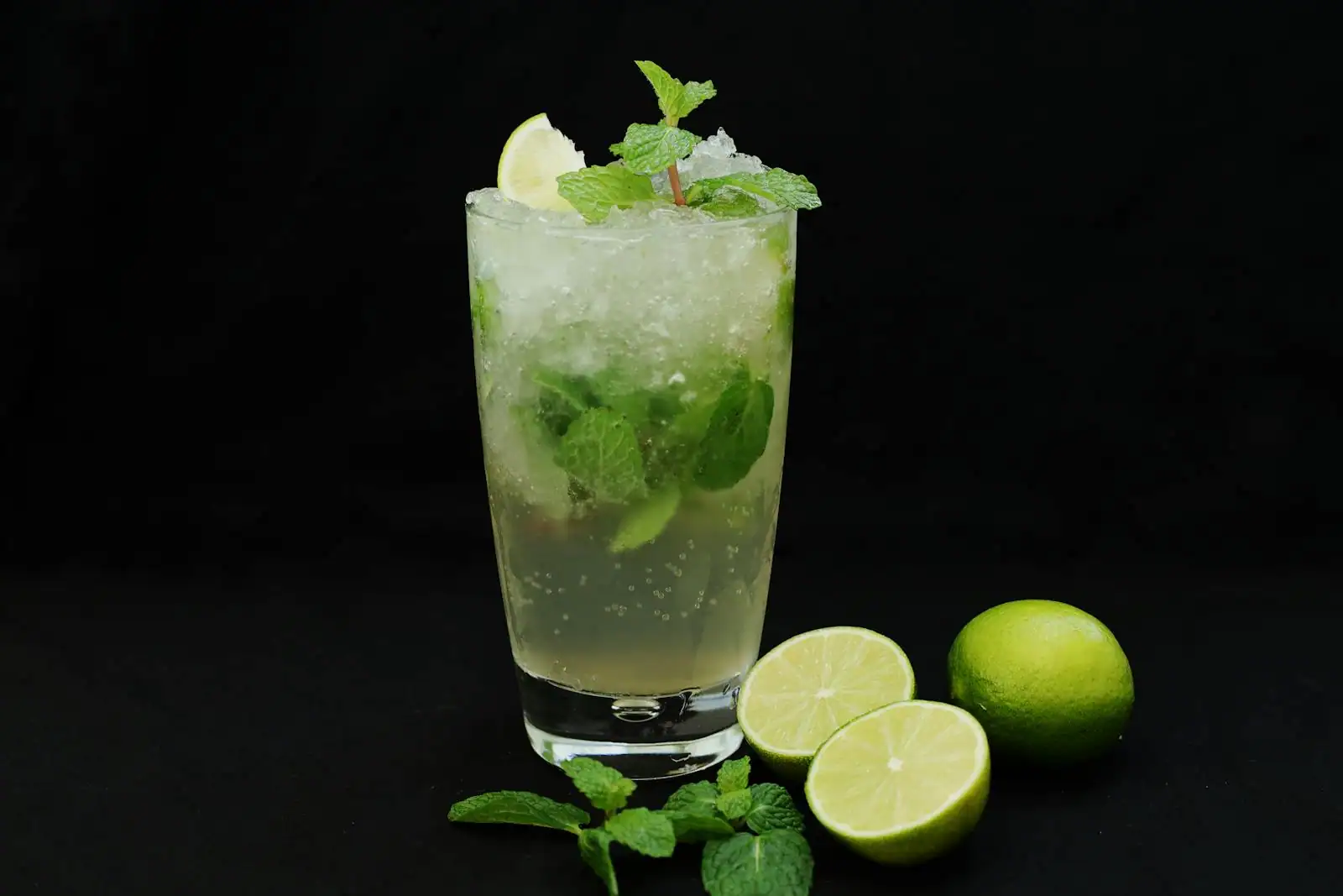 Cocktail Mai Tai servi sur glace pilée avec menthe et demi-citron vert