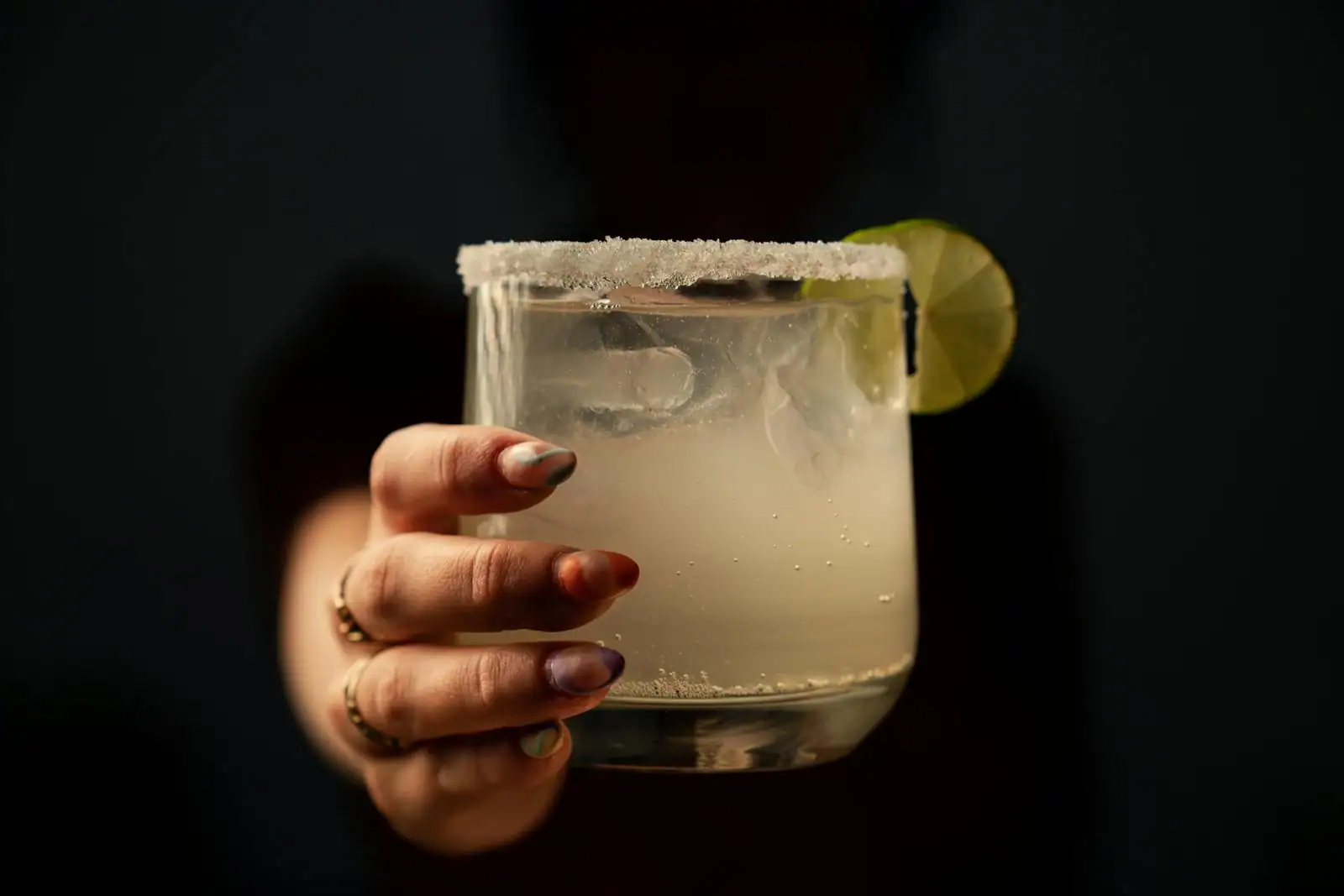 Margarita servie sur glace avec une rondelle de citron vert et un bord de verre givré de sel