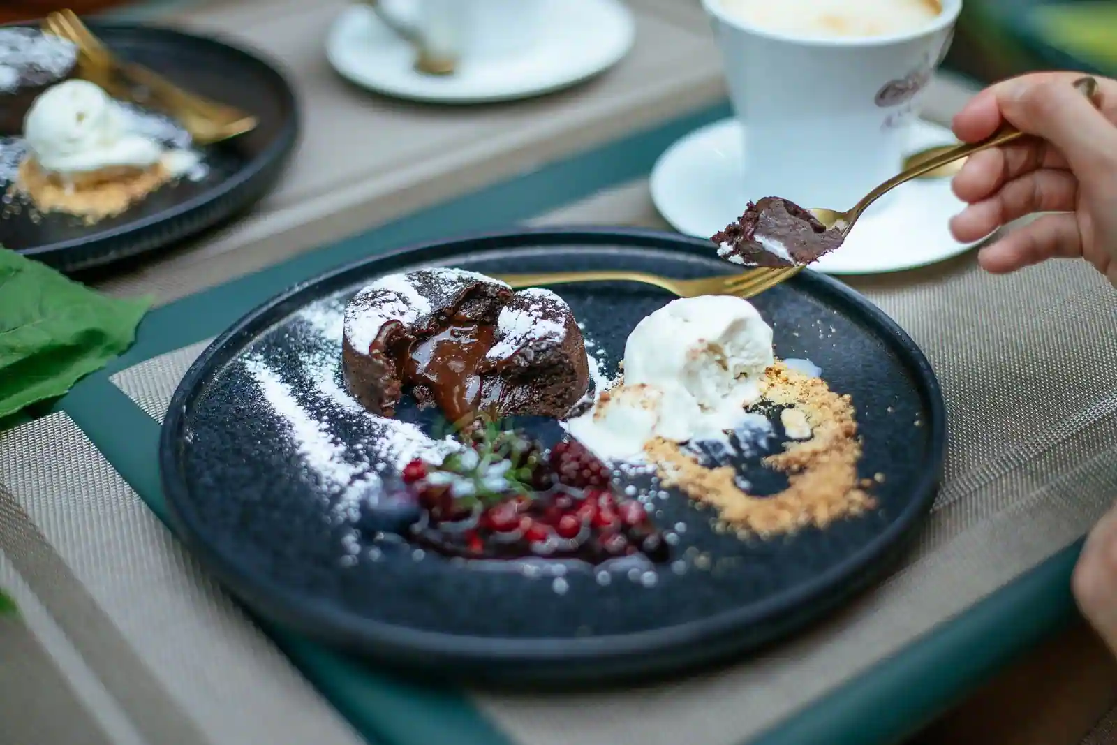 Fondant au chocolat à cœur coulant, sucre glace, boule de glace vanille et fruits rouges dans l'assiette.