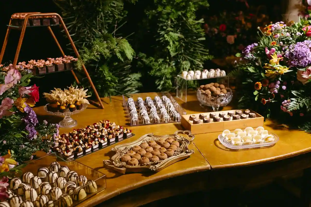 Assortiment de desserts variés dressés sur une table : tarte, crème, mousse au chocolat et fruits.