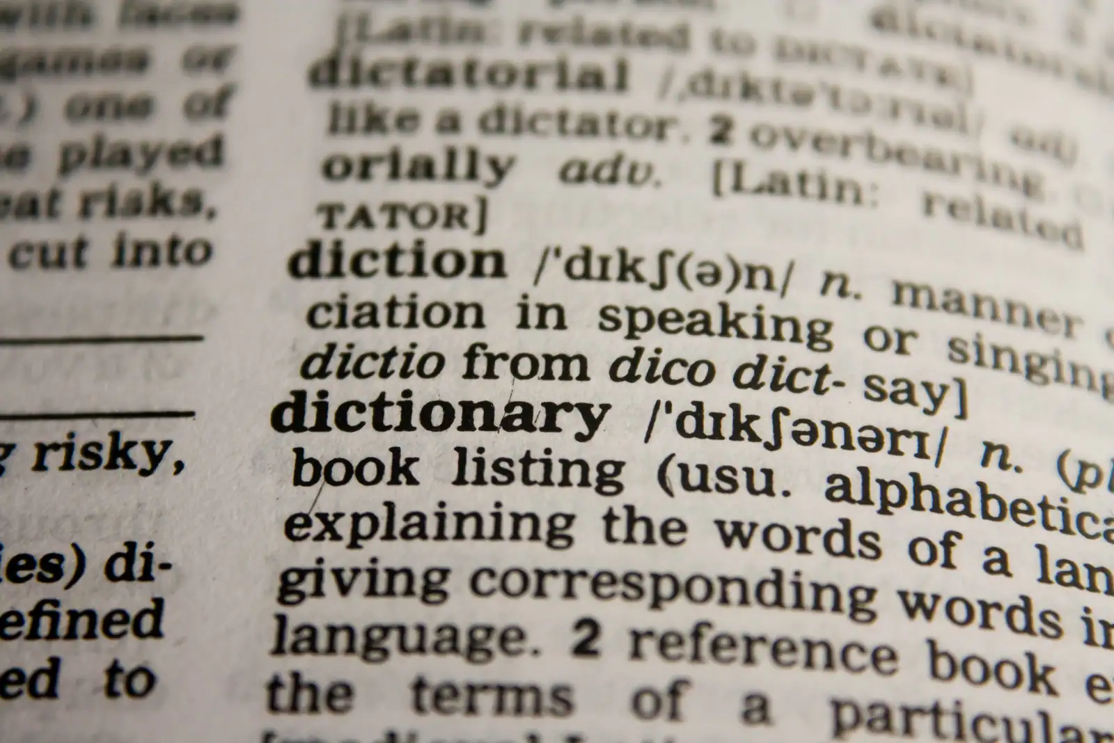 Page de dictionnaire anglais en gros plan montrant la définition du mot « dictionary », sur le thème de la traduction.