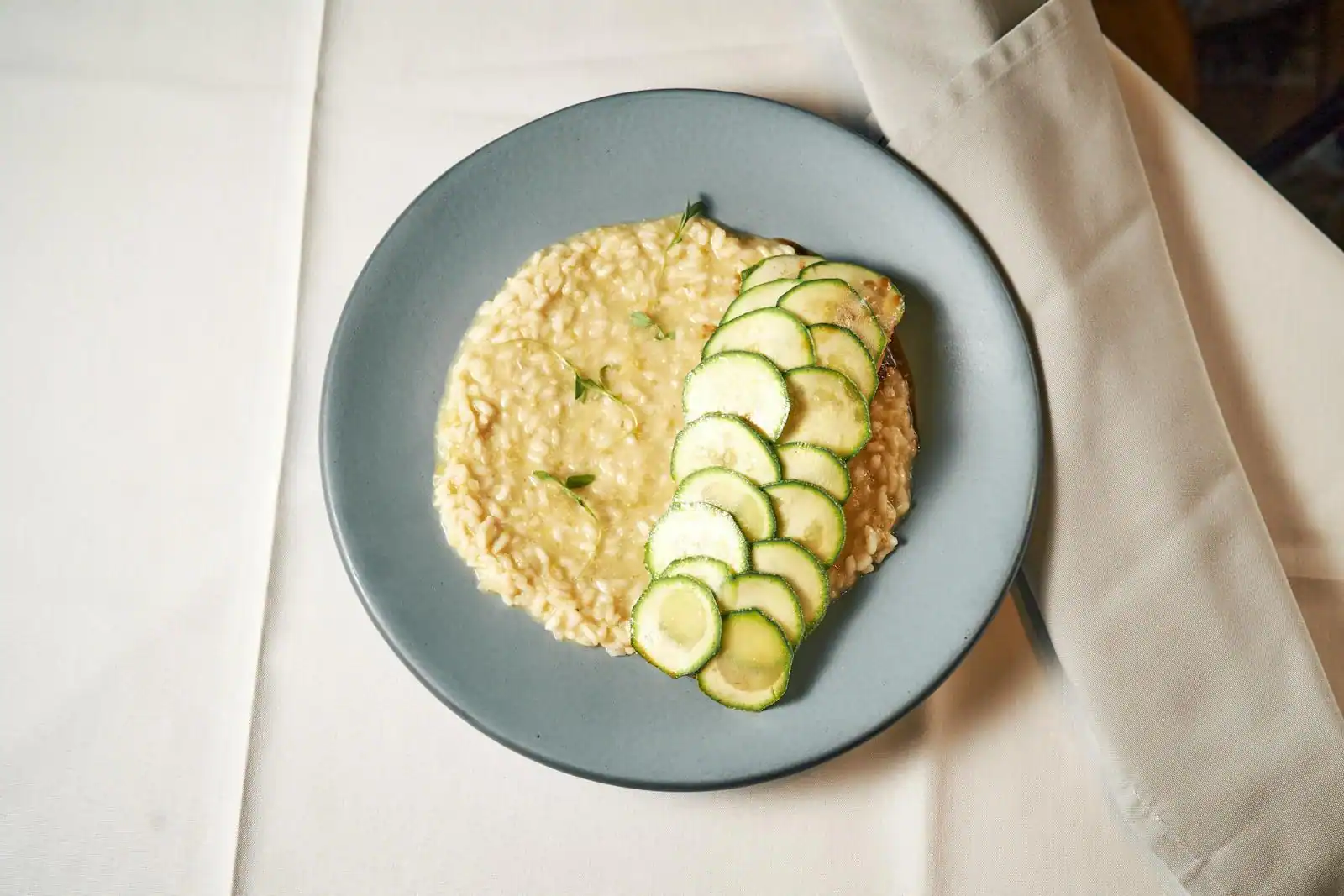 Assiette de risotto crémeux à la courgette parsemé de parmesan