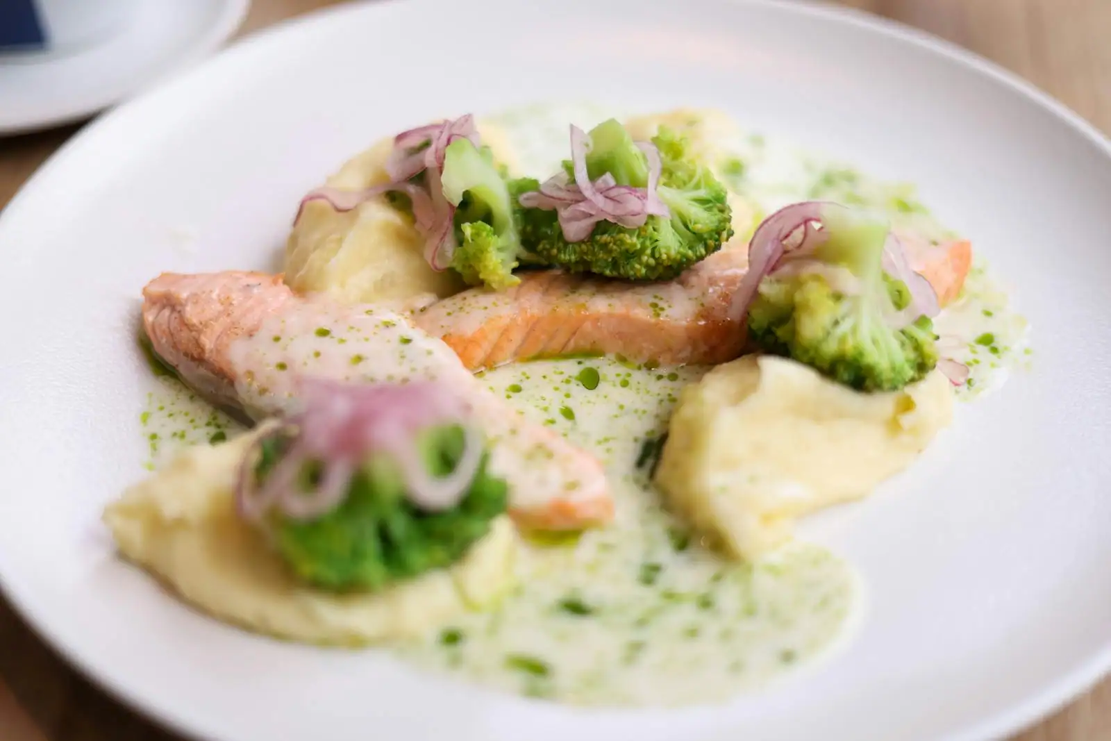 Assiette de risotto crémeux au saumon parsemé d'aneth, servi dans une assiette claire