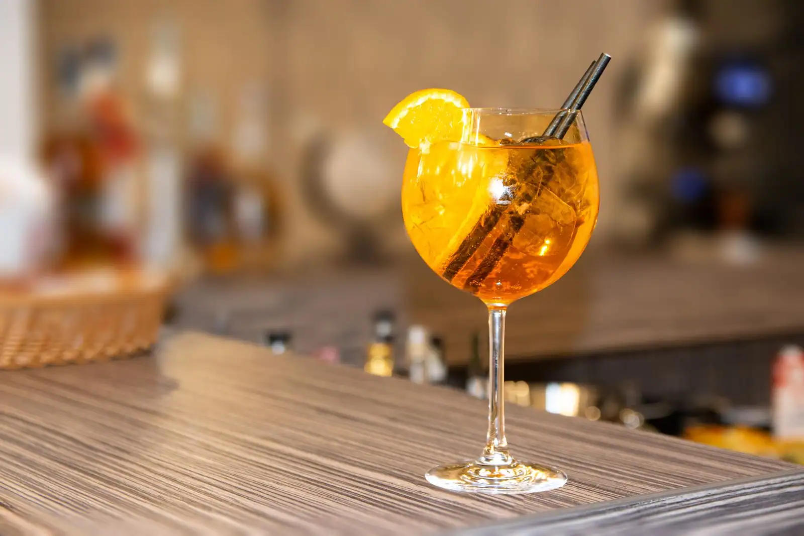 Verre de spritz au prosecco garni d'une tranche d'orange, servi sur glace à l'apéritif