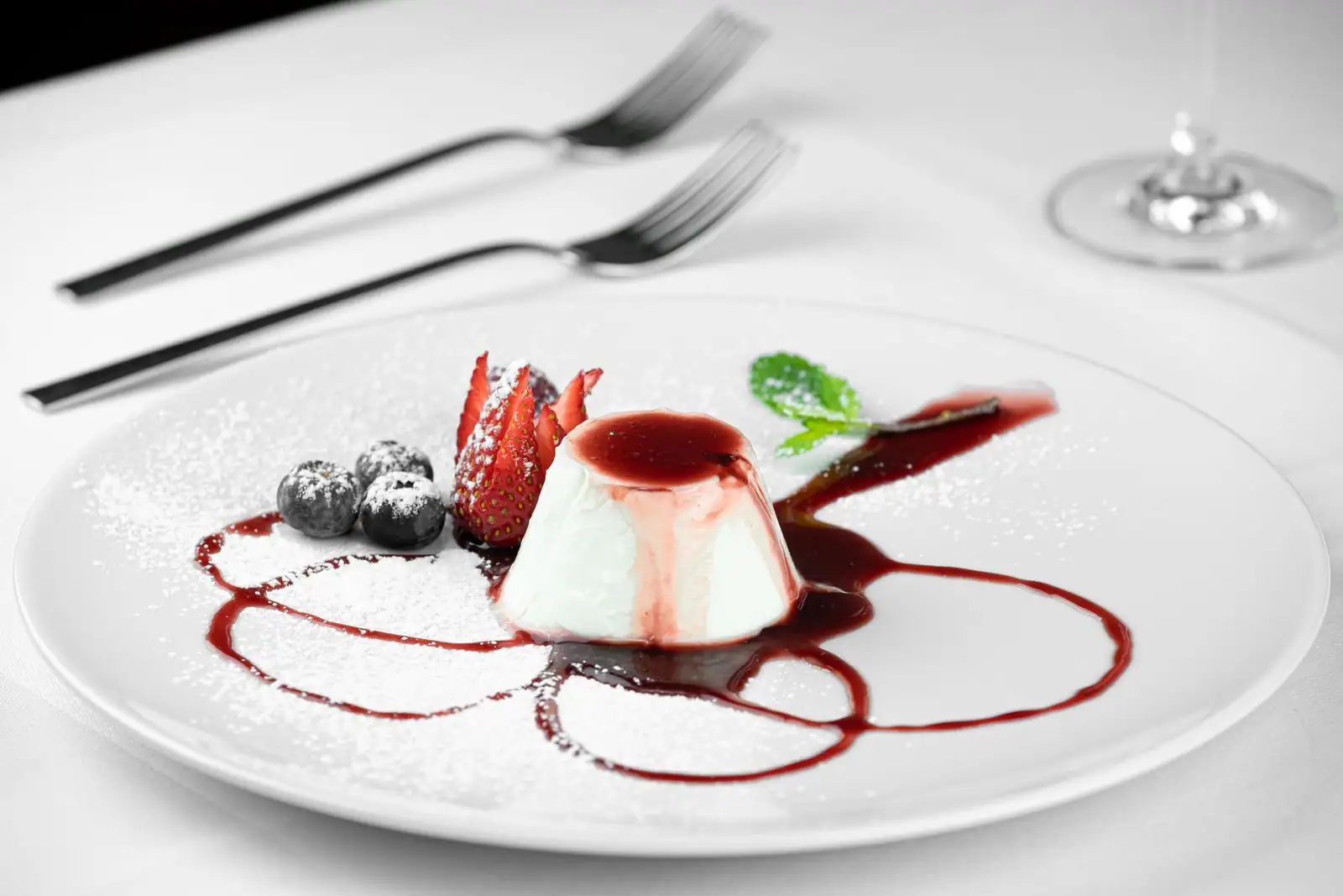 Dessert individuel dressé à l'assiette, crème et coulis de fruits rouges, présentation soignée
