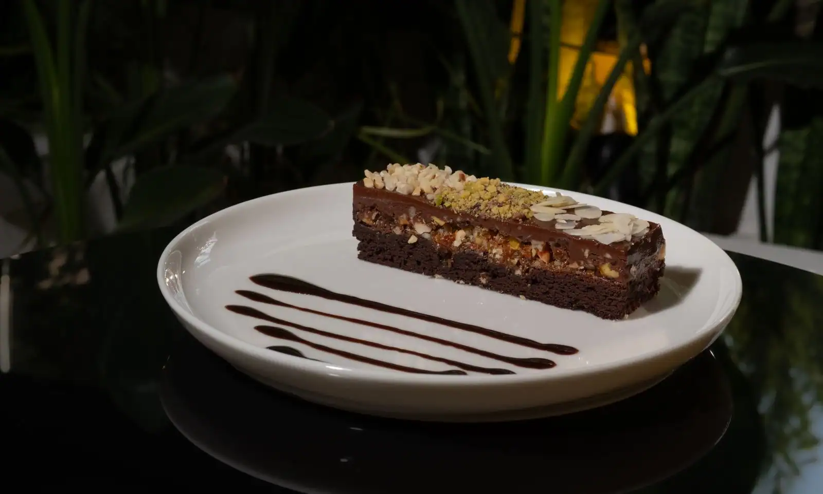 Part de fondant au chocolat et aux amandes sans gluten, servie sur une petite assiette blanche
