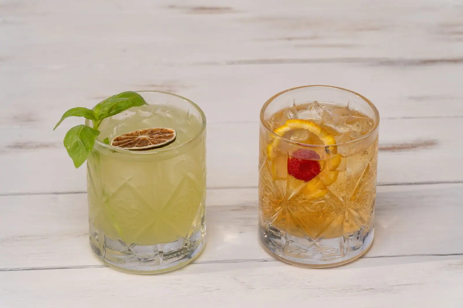 Deux cocktails servis au bord d'une terrasse, agrumes frais et glace