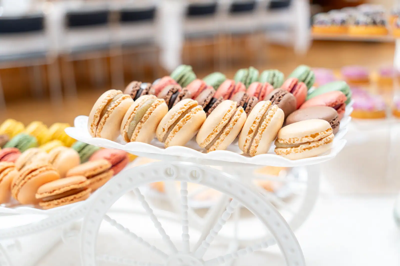 Assortiment de macarons colorés présentés sur un présentoir blanc