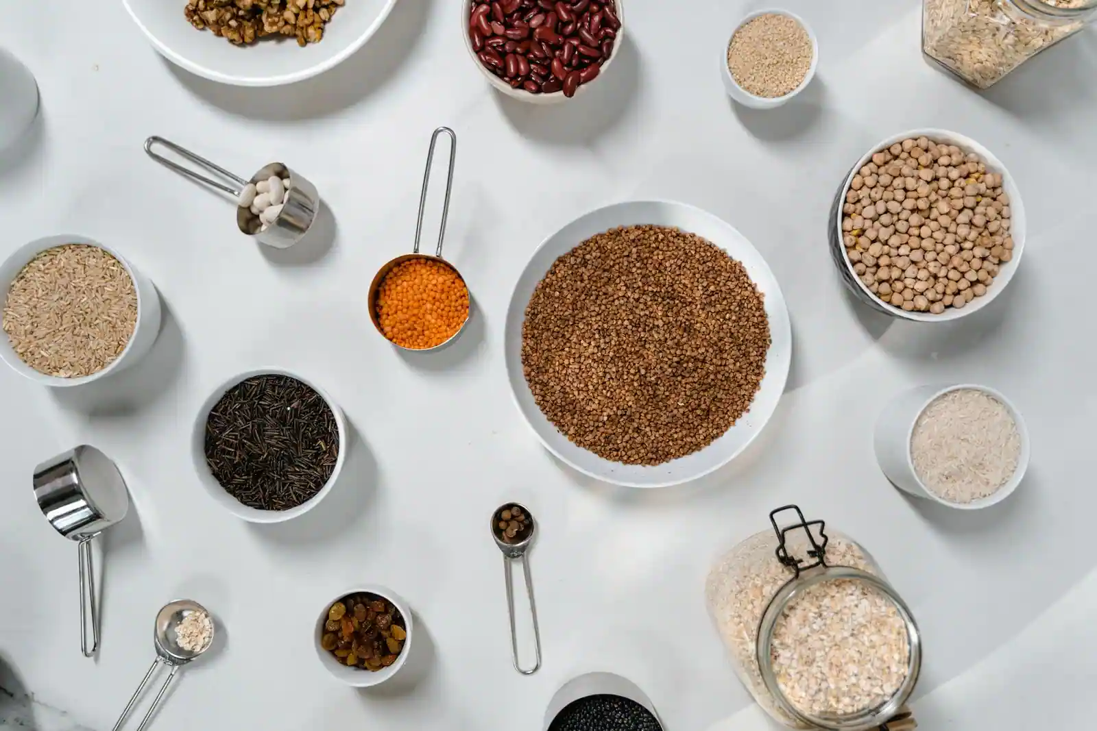 Légumineuses sèches, céréales et graines naturellement sans gluten présentées dans des bols