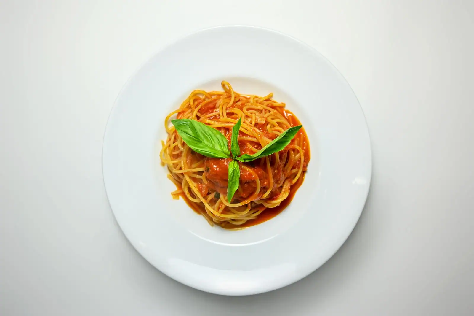 Assiette de pâtes à la sauce tomate et basilic frais, plat italien traditionnel simple