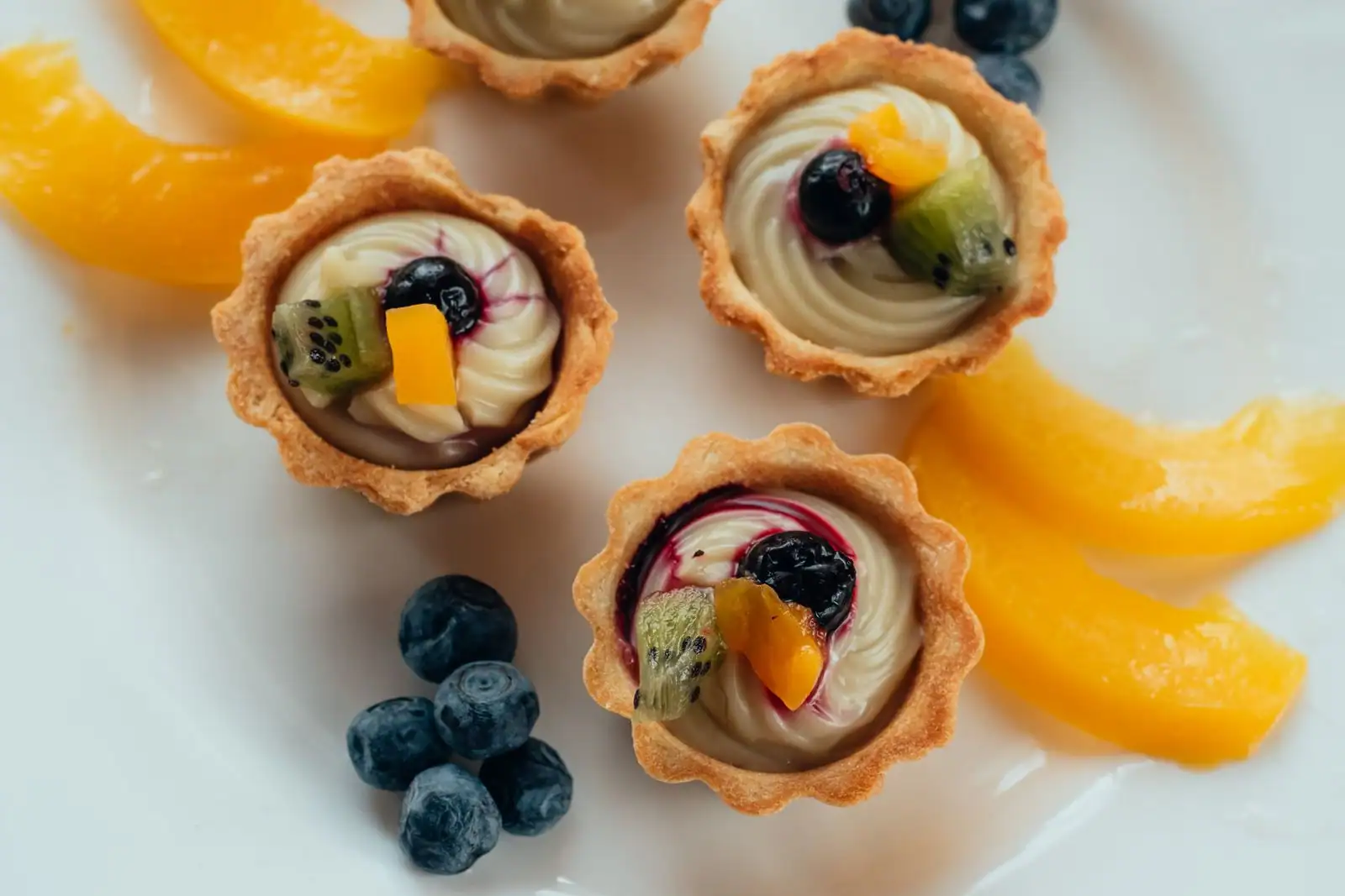 Assortiment de desserts maison présentés sur une table : tartes aux fruits, crèmes et pâtisseries