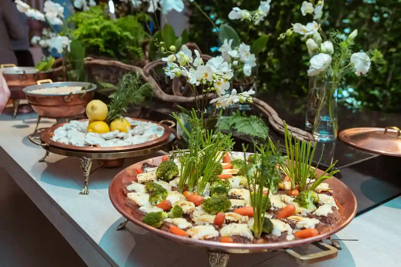 Plats de légumes frais présentés sur des plateaux en cuivre dans une mise en scène gastronomique soignée
