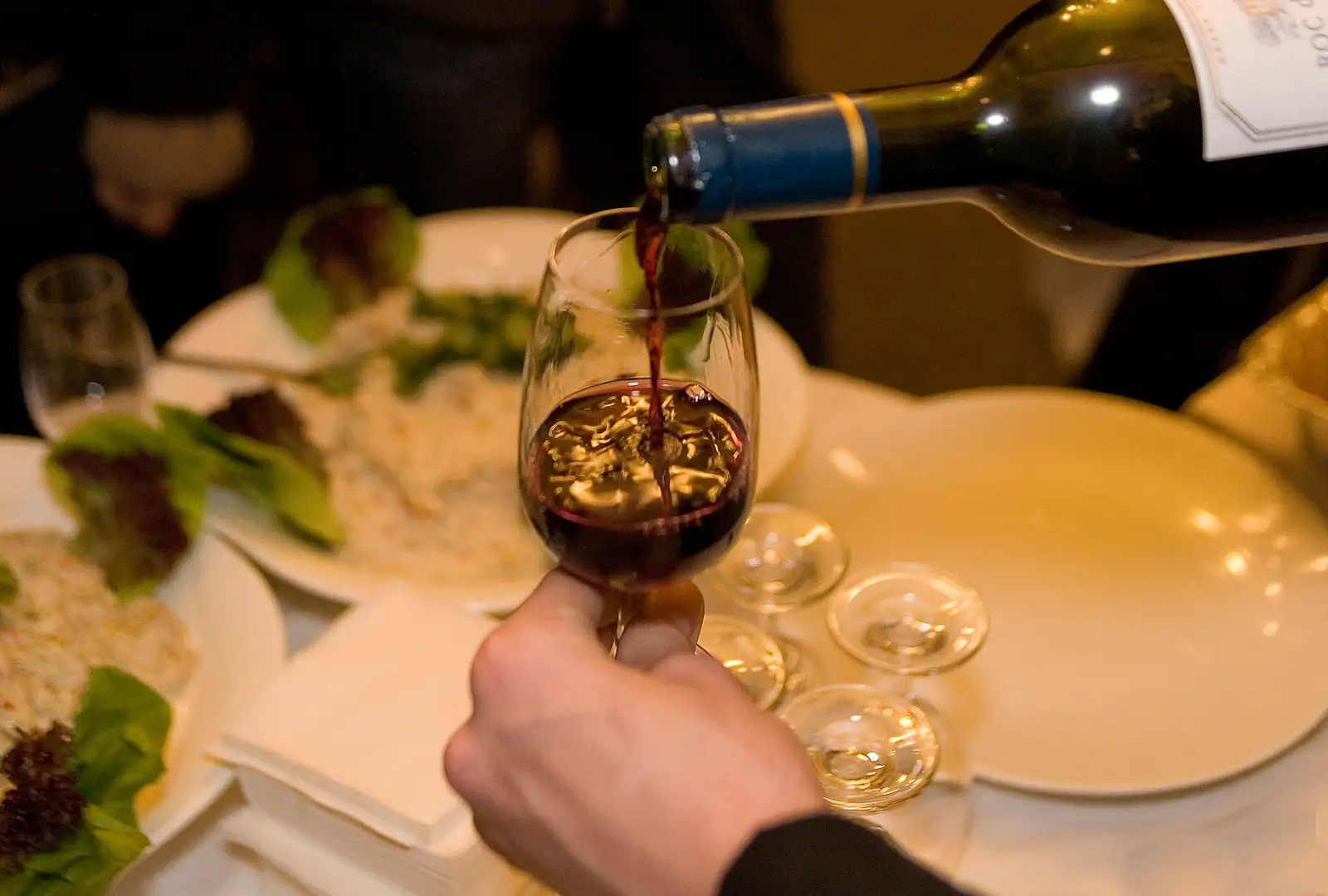 Service d'un verre de vin rouge à table pendant un repas