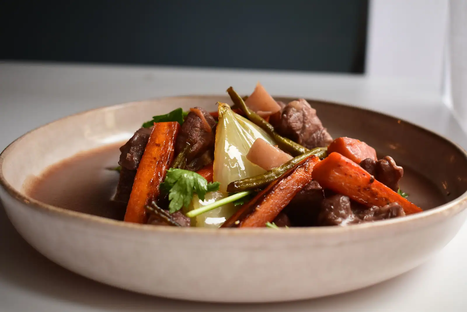 Bol de bœuf braisé aux carottes et à l'oignon, nappé d'une sauce brun rouge brillante
